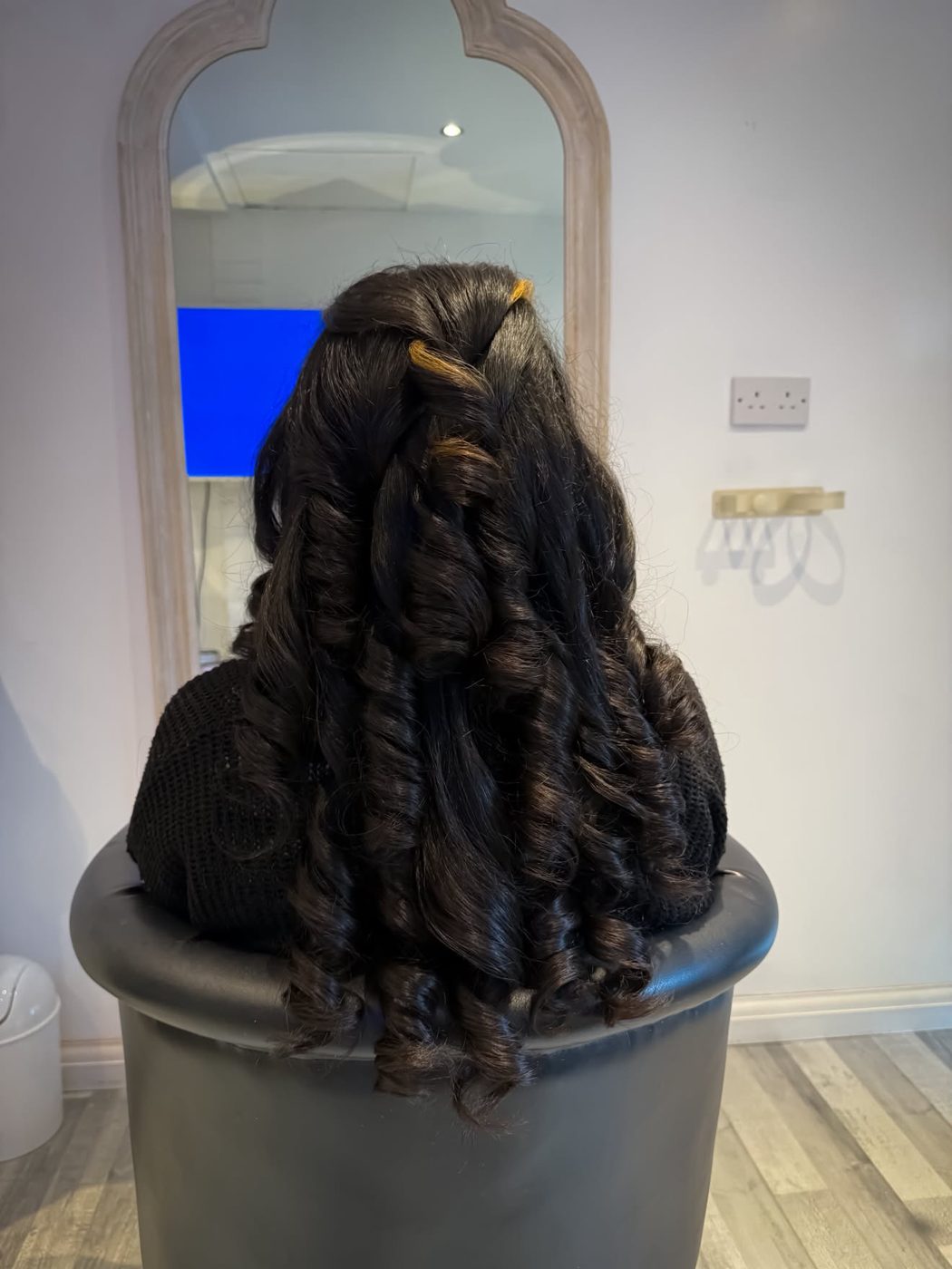 Dark glossy hair styled into full, defined pincurls