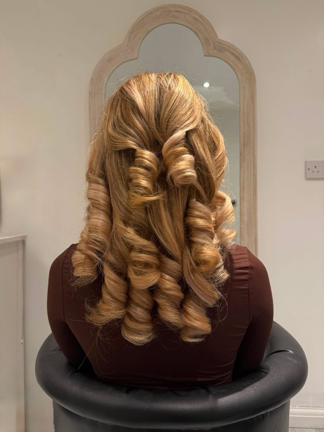 Blonde hair in a half-up style with cascading spiral curls